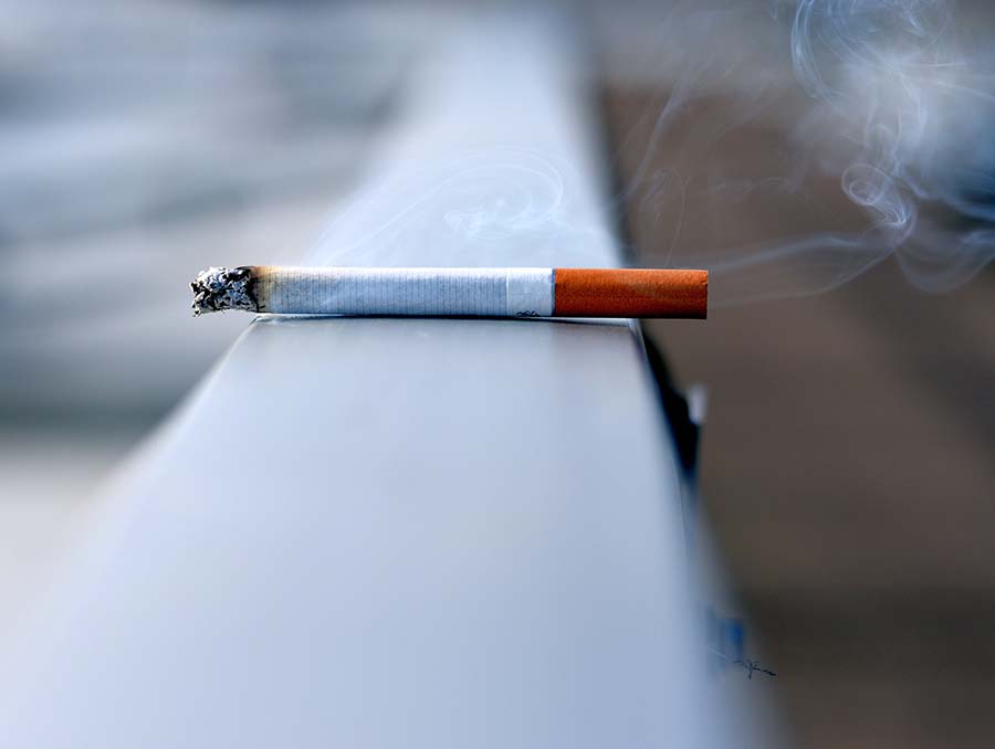 white cigarette burning on white wall 