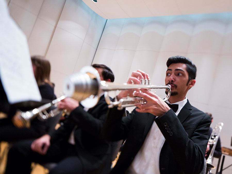 Person playing trumpet on stage during musical performance