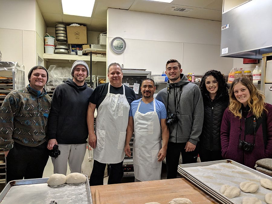 Students pose with local Latino bakers inside a bakery in northern Nevada.