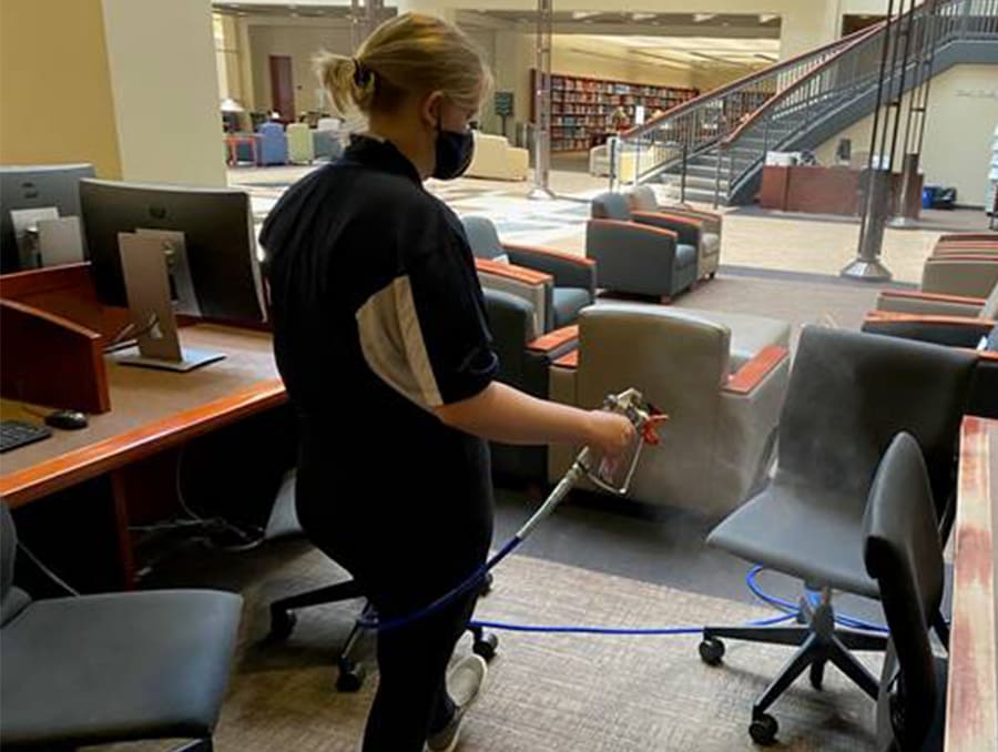 A Libraries Building Monitor uses OPIE to clean chairs inside the Mathewson-IGT Knowledge Center.