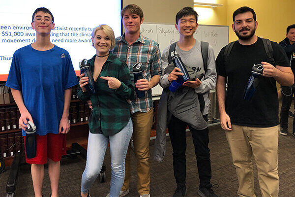 image of 5 students holding up their prize from the University Libraries' Trivia Night 2019.