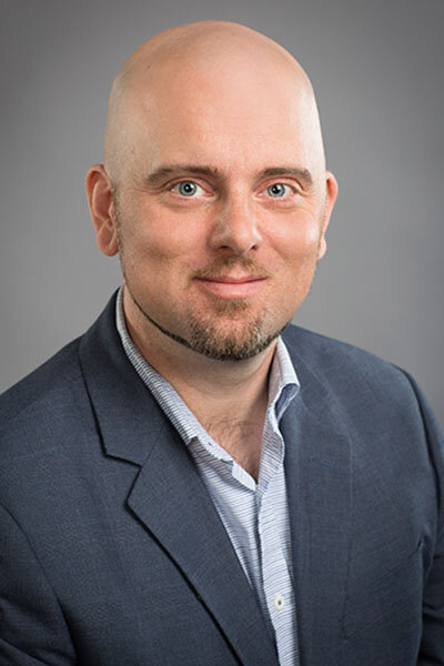 Image of man in a light shirt and dark sport coat 