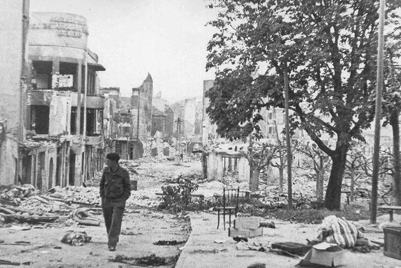 Man walking down the street of Gernika in ruins