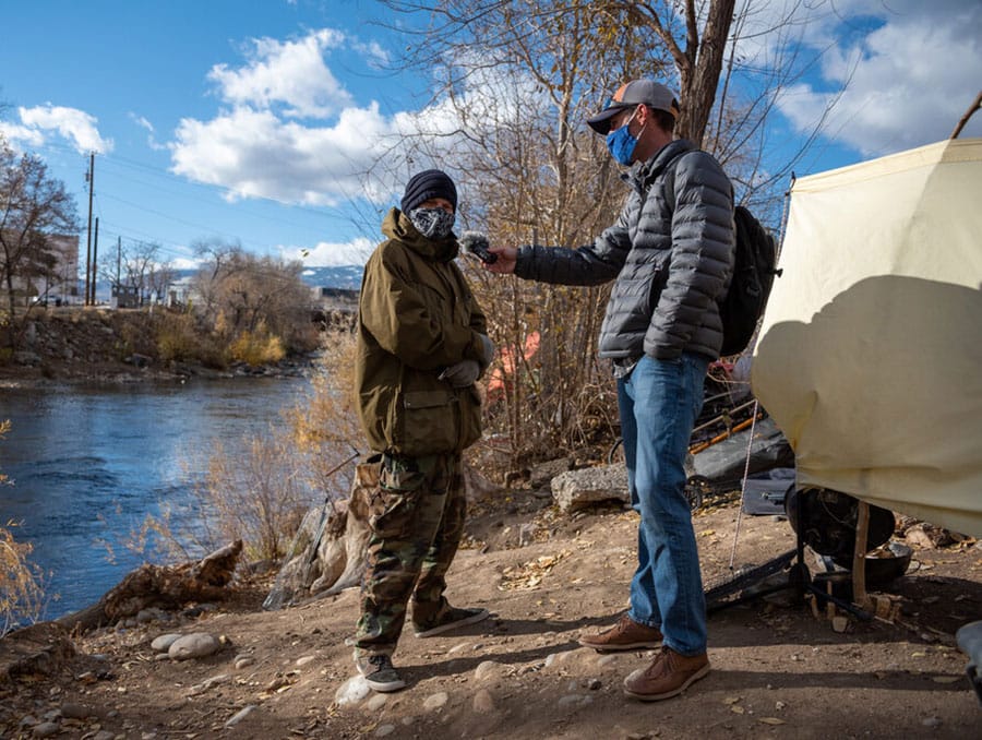 A grad student interviews a community member who lives on the river.