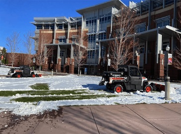 Carver clearing lawn of snow in front of the JCSU