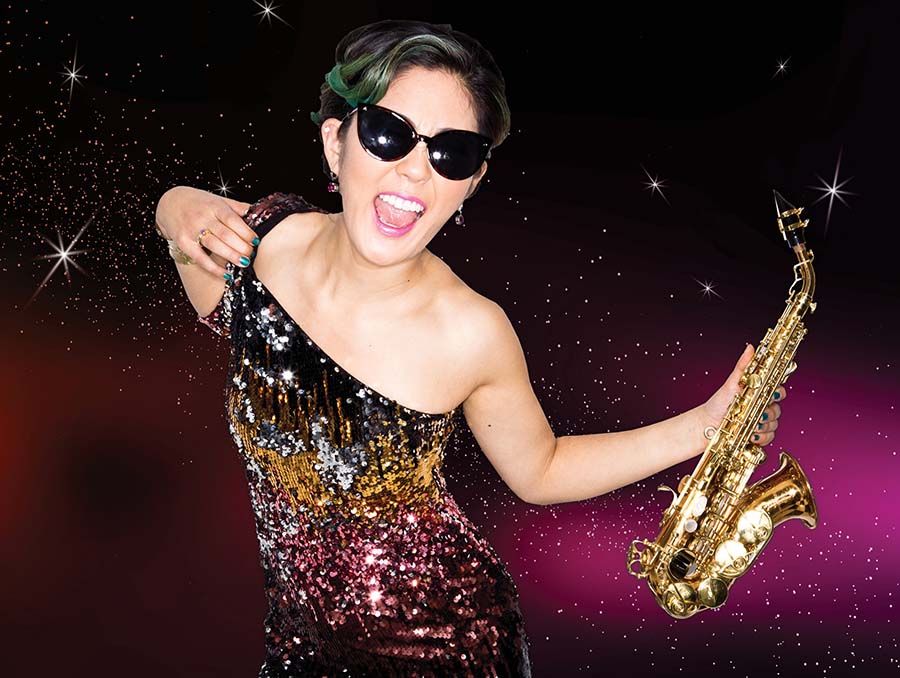 Performer Grace Kelly holds a saxophone.