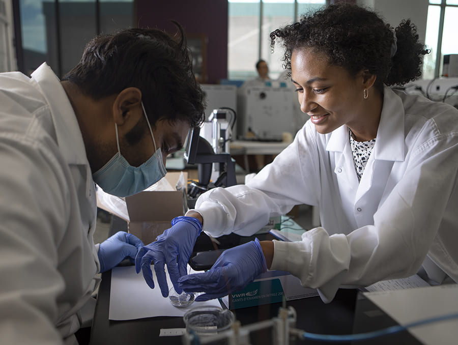 Bailey working with another student in the Khan laboratory.