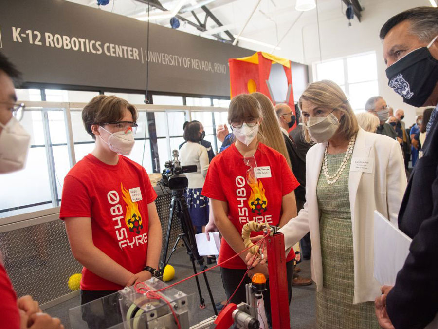 Two teen members of a robotics competition team visit with Nevada's Lt. Governor Kate Marshall and University of Nevada, Reno President Brian Sandoval.