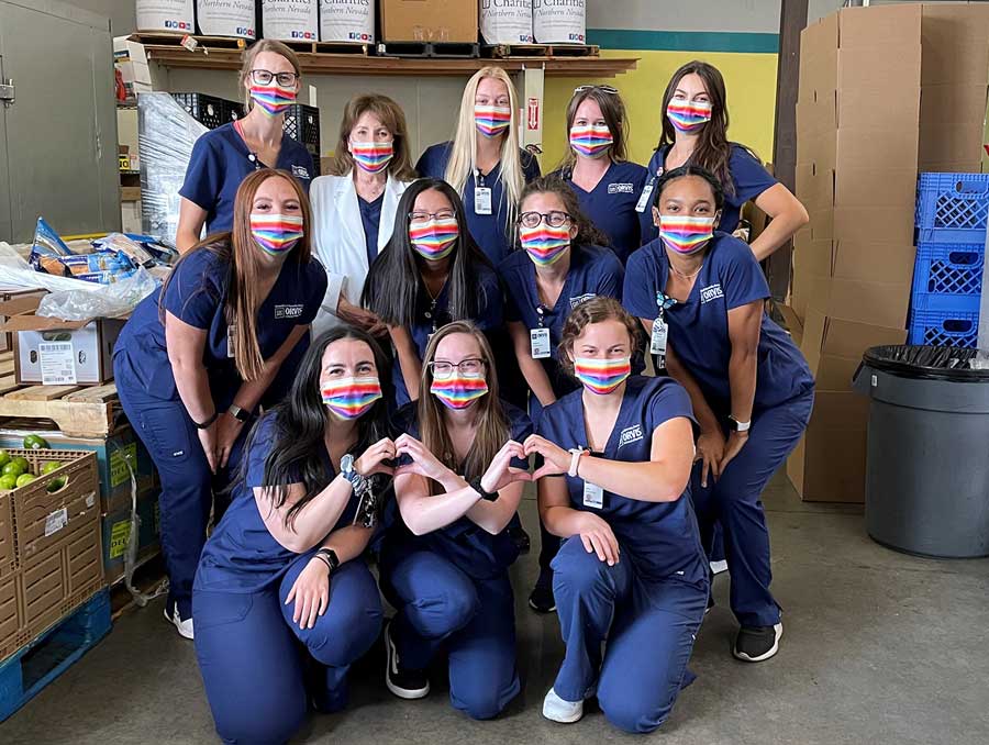 A group of nursing students wearing blue Orvis School of Nursing scrubs and masks