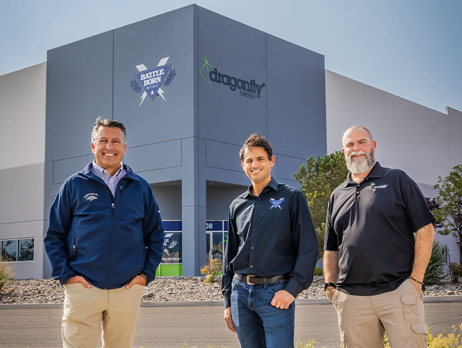 University of Nevada, Reno President Brian Sandoval standing with Dragonfly Energy co-founders, Denis Phares and Sean Nichols, in front of their new warehouse.