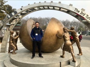 Shawn Thomas with a statue in Korea