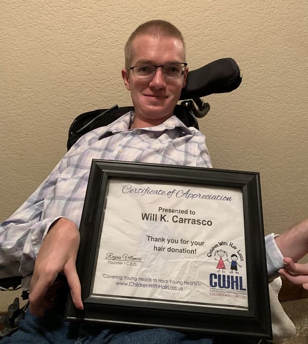 Will Carrasco with a buzzed head and his hair donation certificate