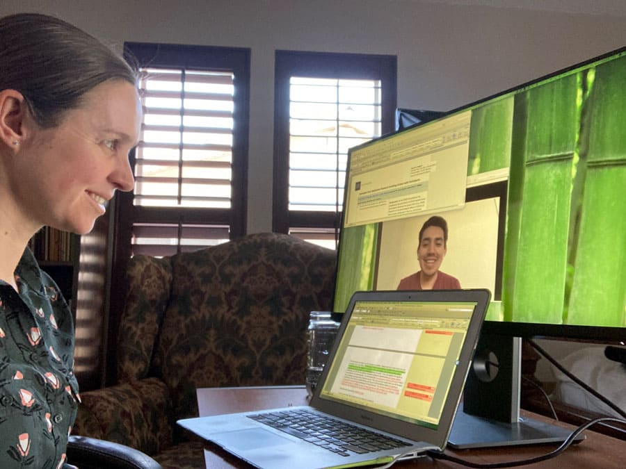 Cynthia Lancaster sits at a desk on a video call with her mentee, Erick Herrera