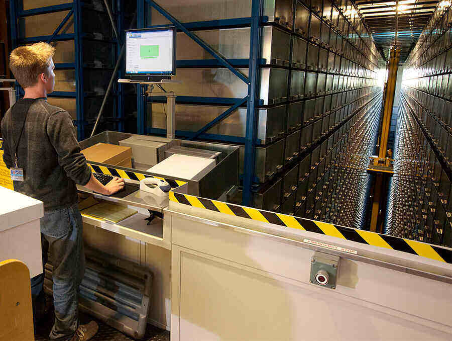 Young man standing in front of a computer that operates the library's ARS. 