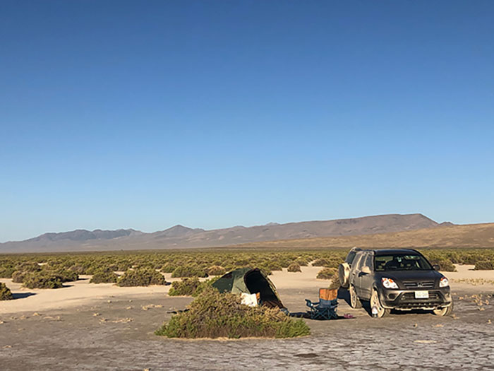 A car and tent set up for camping in the desert