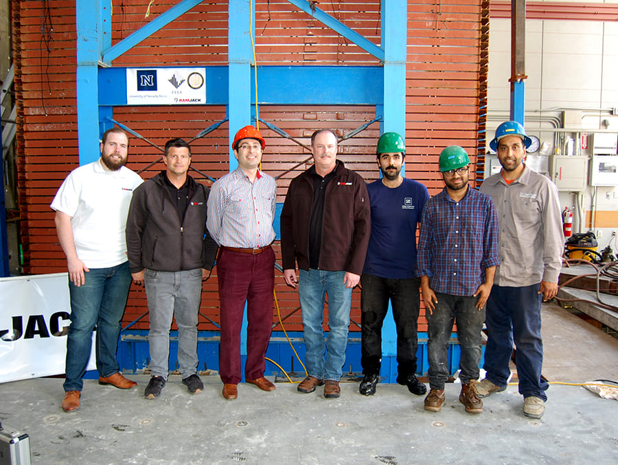 Seven researchers in front of soil box experimental structure