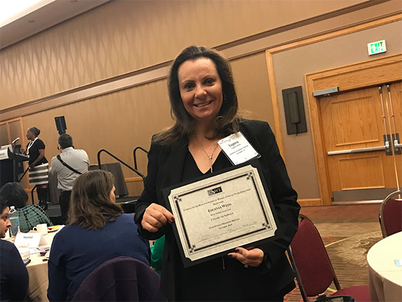 Eugenia Weiss holding an award certificate at an event