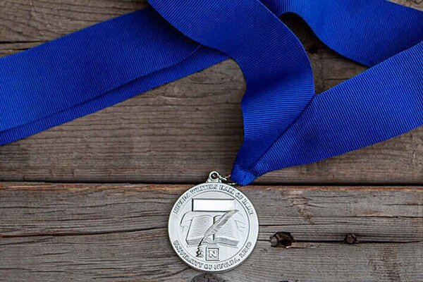 Image of a silver medallion on a royal blue grosgrain ribbon