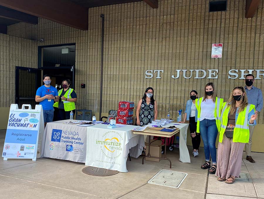 People stand around tables outside St. Therese of the Little Flower in Reno during a COVID-19 vaccination clinic