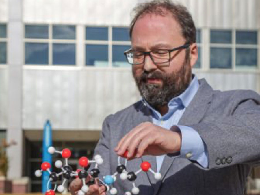 Assistant Professor in the Department of Biology David Alvarez Ponce holds a molecule model.