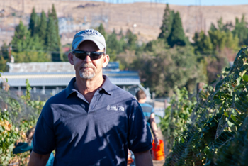 Grant Cramer standing in front of the University vineyard.