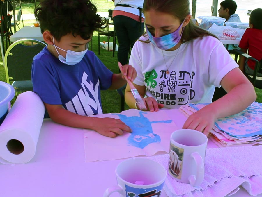 A 4-H youth works with a 4-H leader on a STEM project. See caption for more detail.