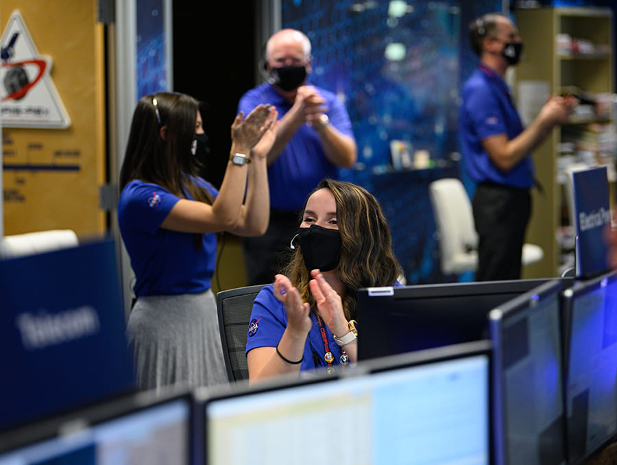 People clapping in computer-filled room.