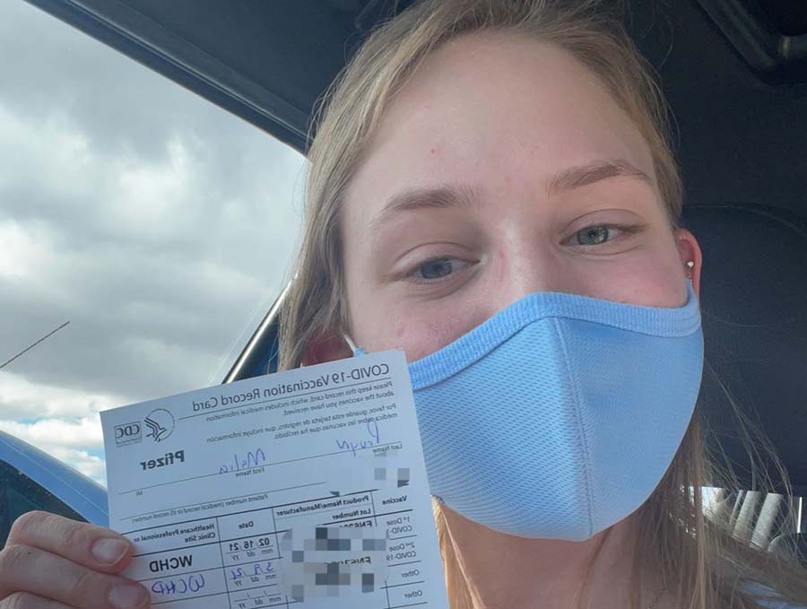 Malia Pruyn holding a COVID-19 Vaccination card