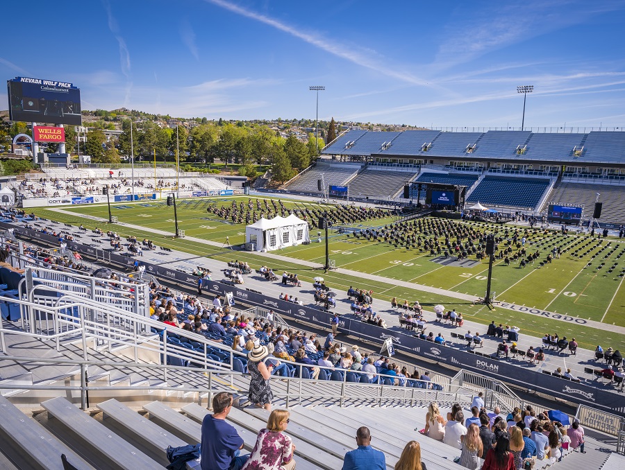 A view of Spring 2021 Commencement from the stands of Mackay Stadium, showing the crowd and all graduates socially distanced, the stage, and really everything else