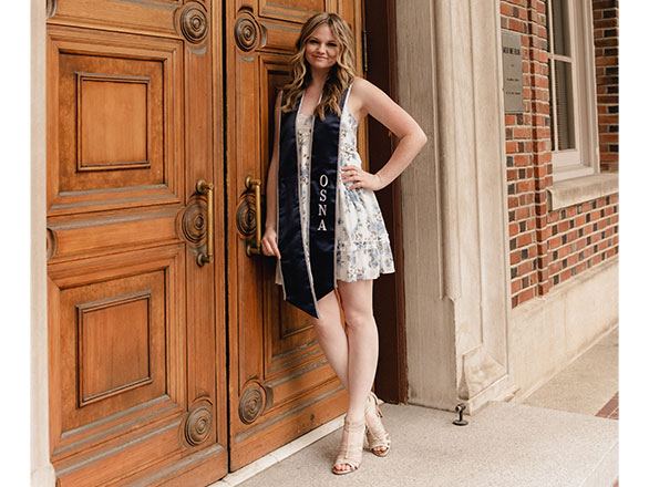 Nikki Stone graduation photo in front of wooden doors