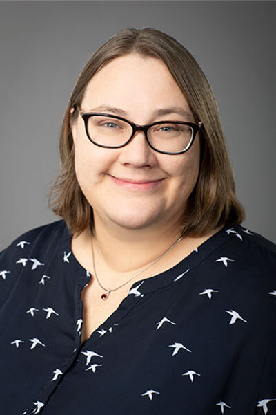 Portrait of a woman wearing glasses and a navy blouse