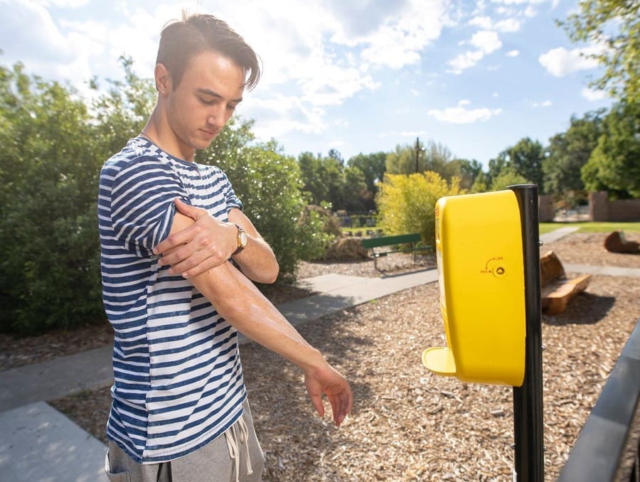 A student putting on sunscreen