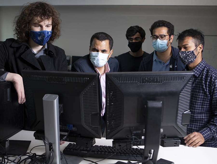 Researchers in laboratory looking at computer screens.