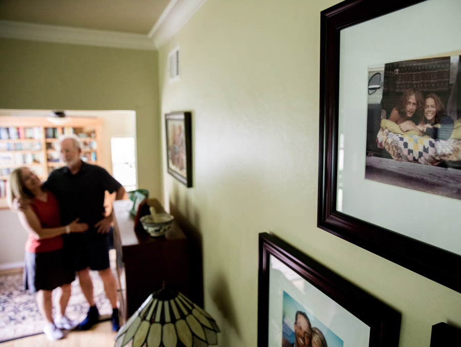 Patrick and Karen Ghezzi stand in the background, with the foreground focused on a photo.