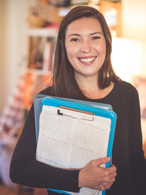 Staheli Meyer smiles, holding a binder.