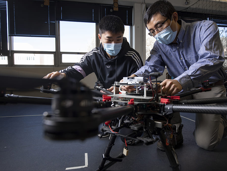 Hao Xu and student working on drone together in Xu's lab.