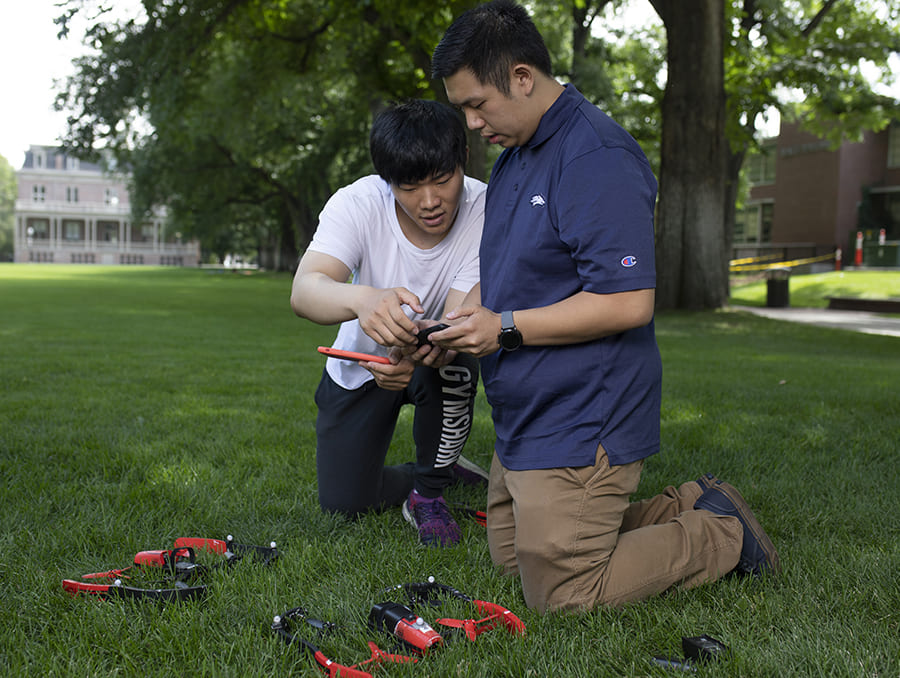 Students on Quad investigating a drone