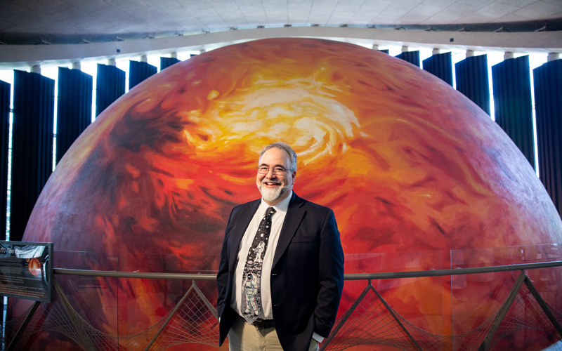 Paul McFarlane stands in front of the dome theater, which is painted to look like the sun.