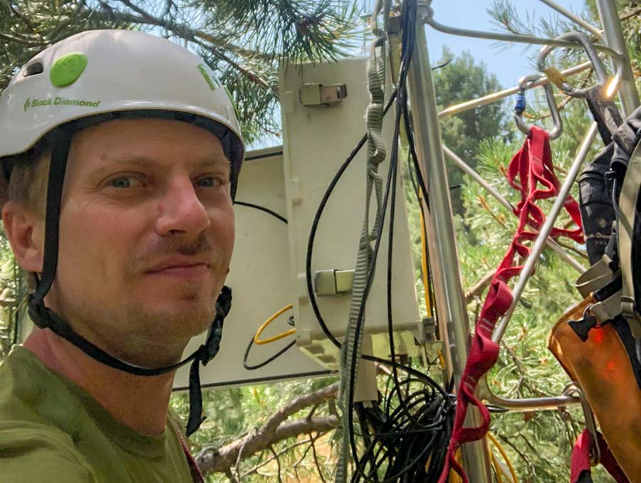 Adrian Harpold working with technology in a forest. 