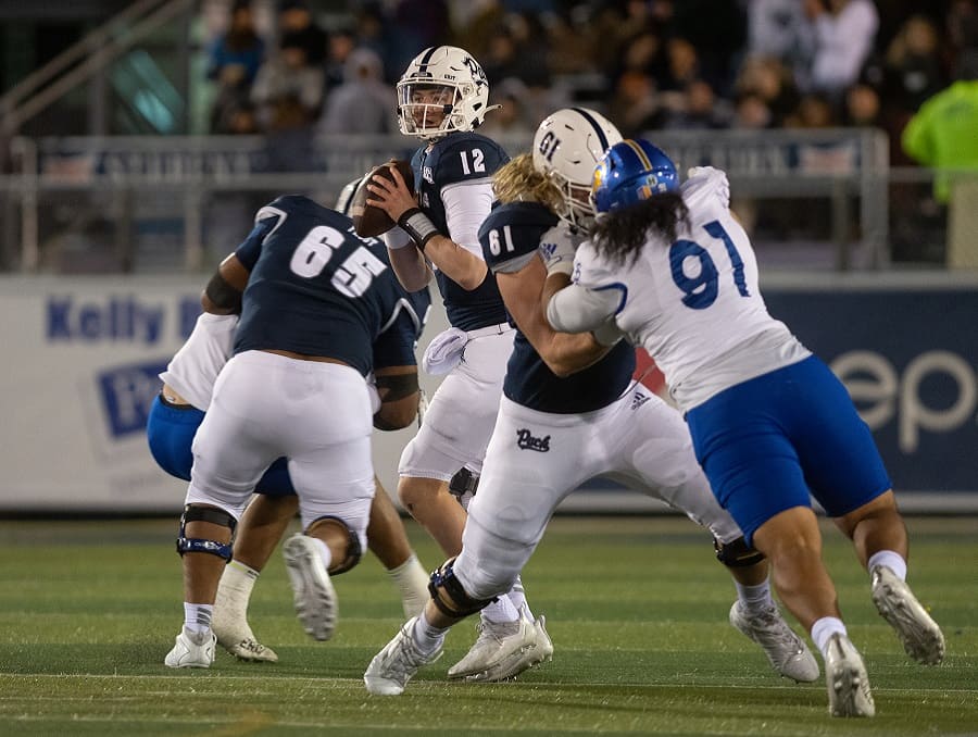 Carson Strong and Wolf Pack teammates on the field during a football game