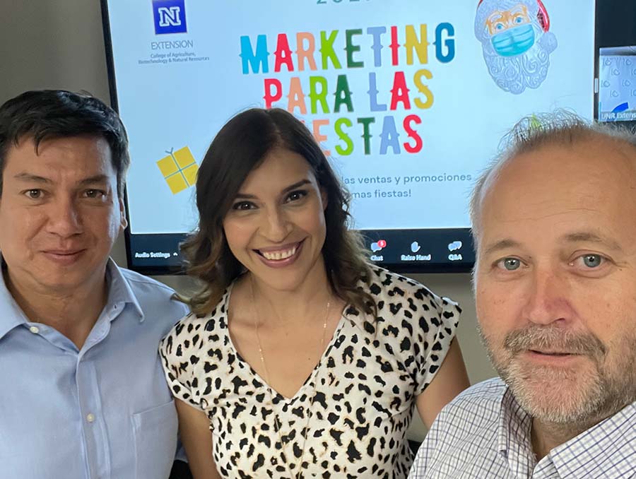 Business instructors Juan Salas, Reyna Mendez and Mike Bindrup posing in front of a screen. 