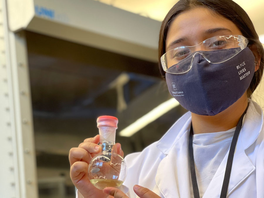 Yareli Navarro Chavez in a lab holding a vial.