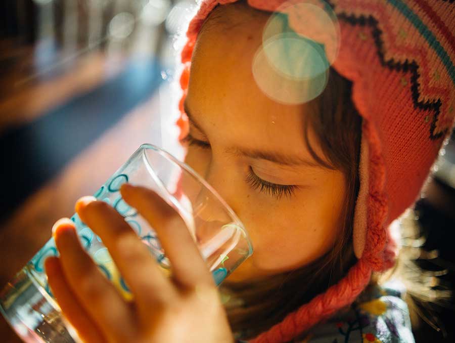 A child drinking from a glass of water