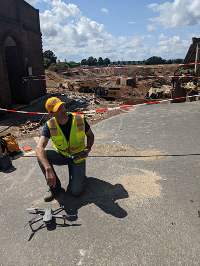 Michael Gardner kneels next to drone.