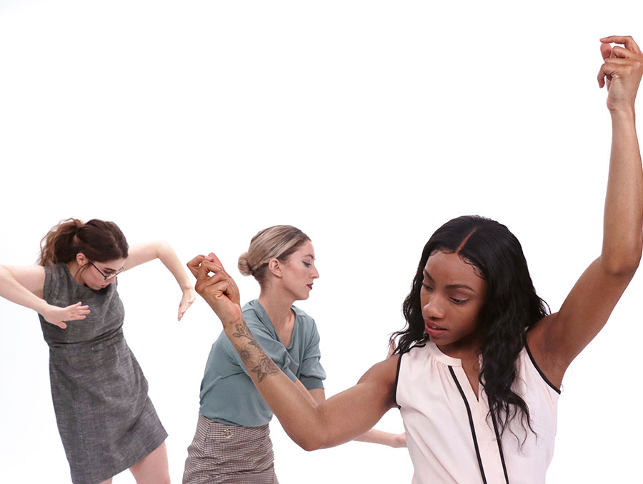 Three individuals dance with arms in the air