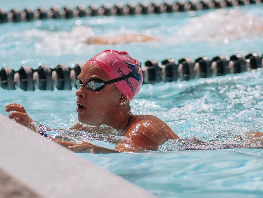 Mariana Vignoli swimming hard in the pool at practice, just about to finish a lap and turn around