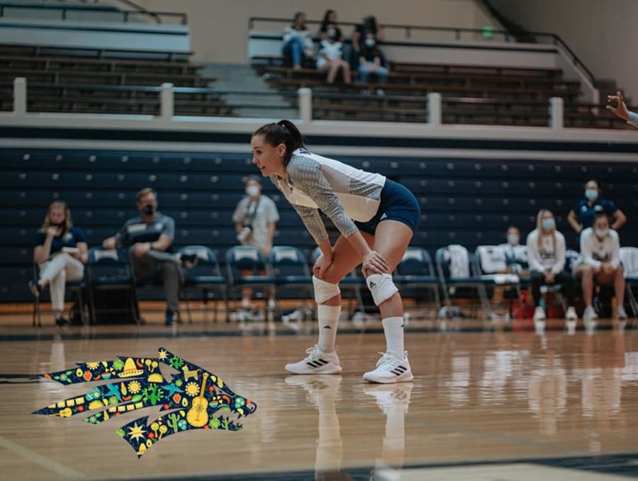 Andrea Alcaraz on the volleyball court during a game with the Athletics sport wolf logo decorated for Latinx Heritage Month