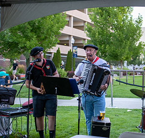 Basque band members sing and play accordion and drums outside