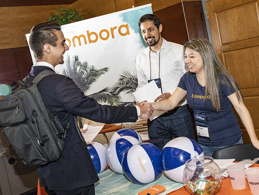 Employer and student shaking hands at table