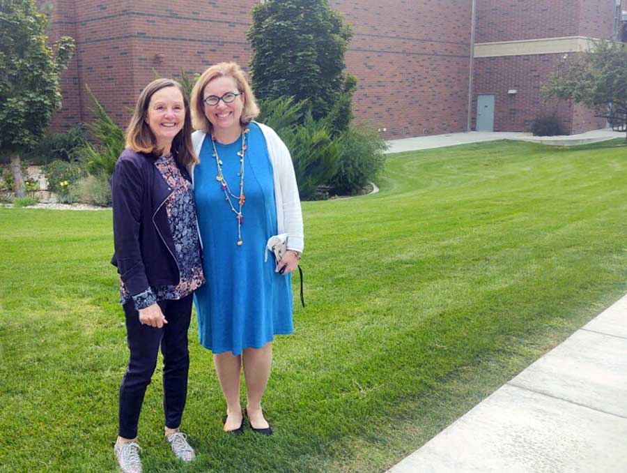 Dean Debera Thomas, left, and Dean Muge Akpinar-Elci, right, standing outside in grass on University of Nevada, Reno campus